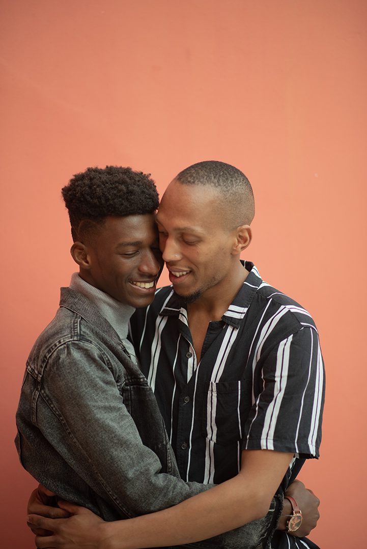 Two men are hugging and smiling for the camera.